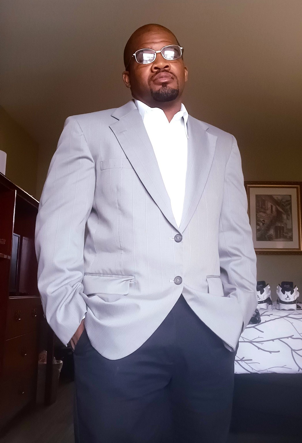 Kevin High, creator and artist behind SUM GREATNESS LLC, wearing a light grey jacket